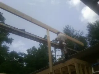 Carpenter setting a ridge beam over a new addition frame — Ice Dam Removal by Roofing Brothers in Mc Sherrystown