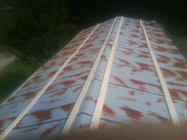 Rusted metal roof panels with new wood purlins before replacement — Storm Damage Roof Repair in Mc Sherrystown by Roofing Brothers