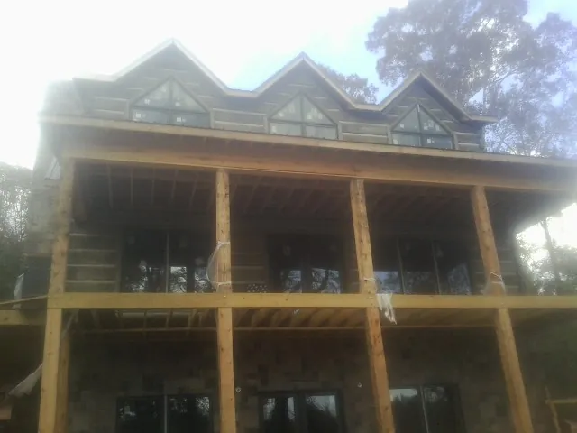 Dormers and porch framing on a large log home under construction — Roof Coating work by our crew in Mc Sherrystown