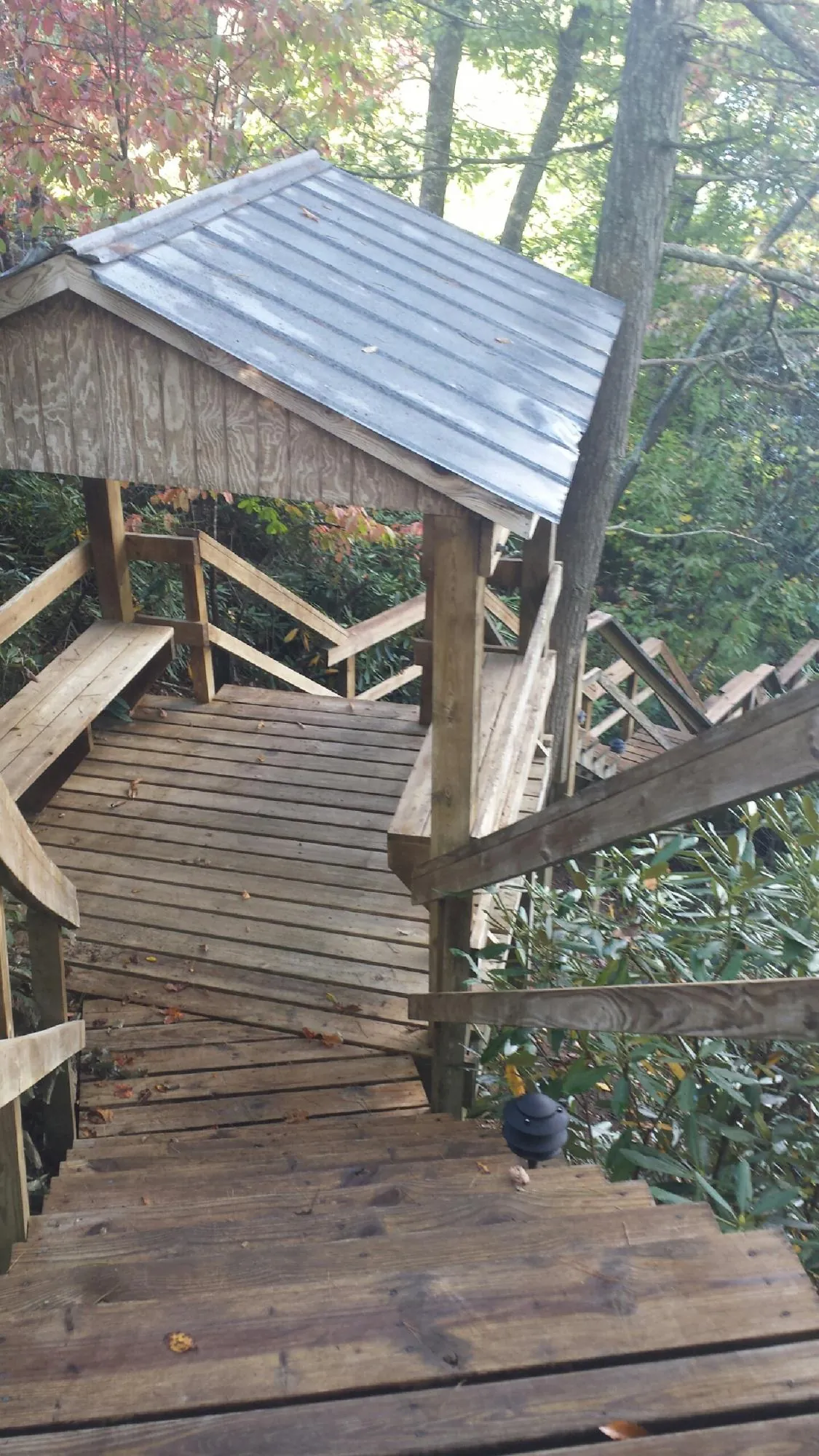 Metal roofed shelter over wooden steps on a wooded walkway — Skylight Repair & Installation work by our crew in Mc Sherrystown