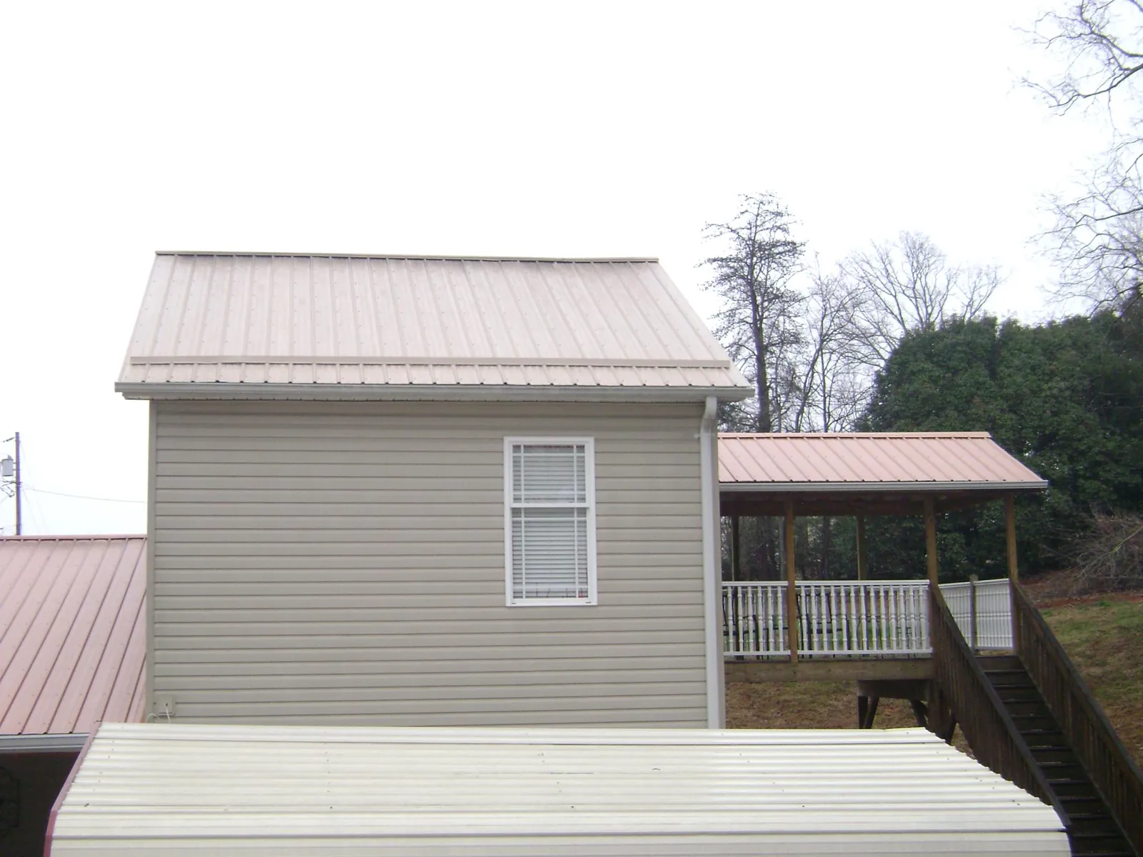 Tan metal roofs on a two story addition and attached porch, from a Roof Replacement job in Mc Sherrystown